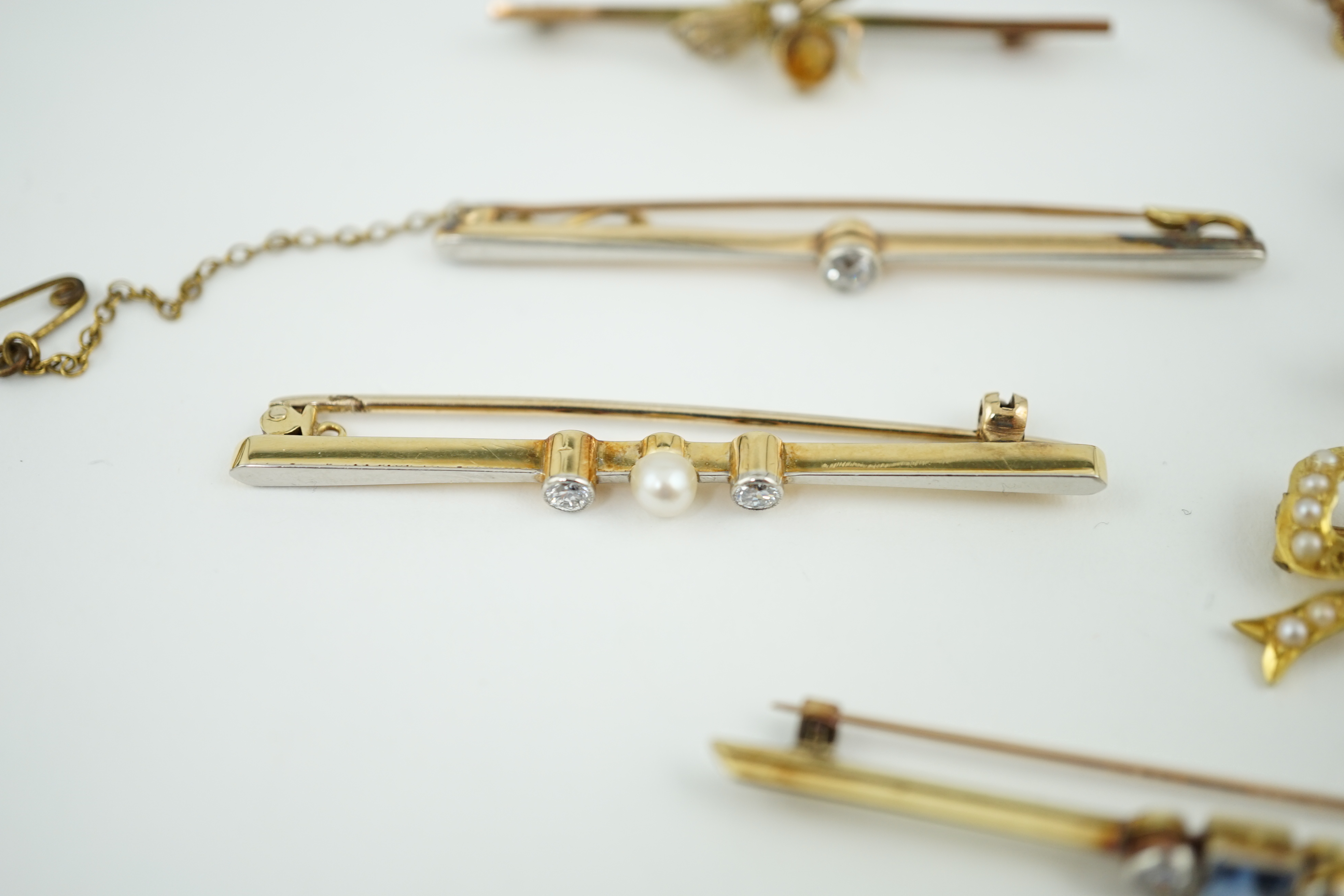 Five assorted Edwardian bar brooches, including a 15ct gold sapphire and diamond set three stone, a diamond and seed pearl, ruby? and seed pearl, a solitaire diamond set and a seed pearl and citrine bug brooch